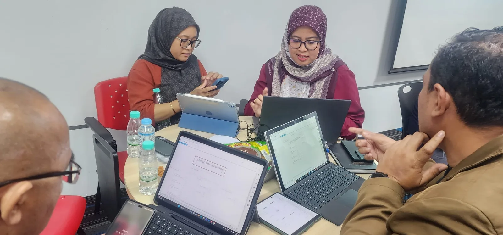 Group discussion around shared laptops